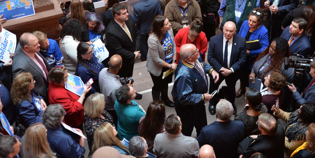 PEF Secretary Treasurer Joe Donahue (center, in jacket) addresses a Tier 6 rally on a landing of the Million Dollar Staircase inside the State Capitol on March 5, 2024.